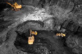 Site d'extraction de terres rares montrant une mine à ciel ouvert, des machines lourdes, et un paysage aride, avec des quartiers de travailleurs visibles en arrière-plan