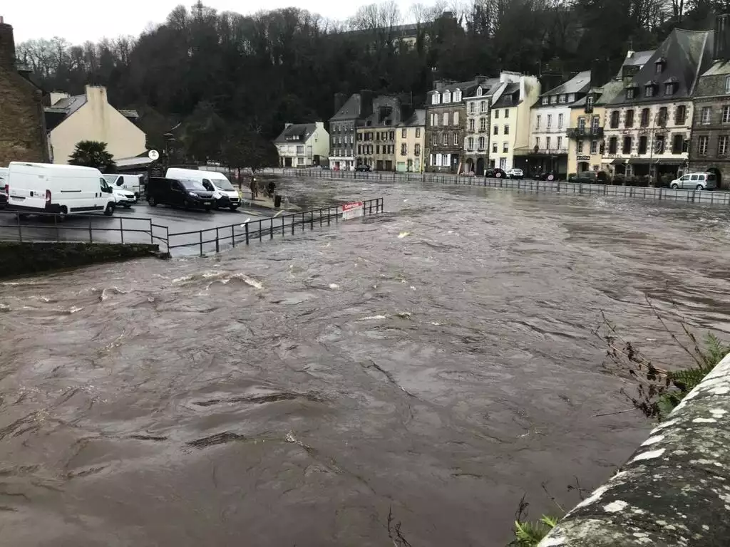 Rivière en crue débordant sur ses berges avec des maisons situées à proximité, en Ile-et-Villaine