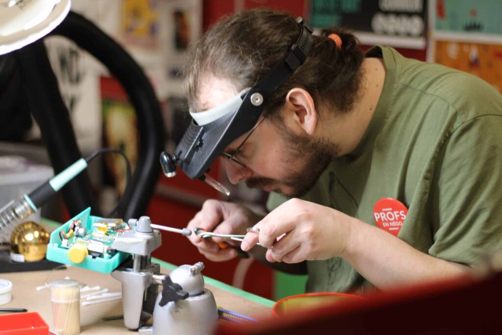 Réparation d’un appareil électronique dans un atelier spécialisé au Québec, symbole de l’économie circulaire.